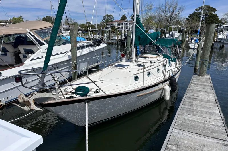 The Image of 1986 Pacific Seacraft 34 sailboat docked at a marina, surrounded by other boats. - 1