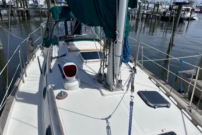 Slide: The Image of 1986 Pacific Seacraft 34 sailboat docked at marina, showcasing deck and rigging. - 10