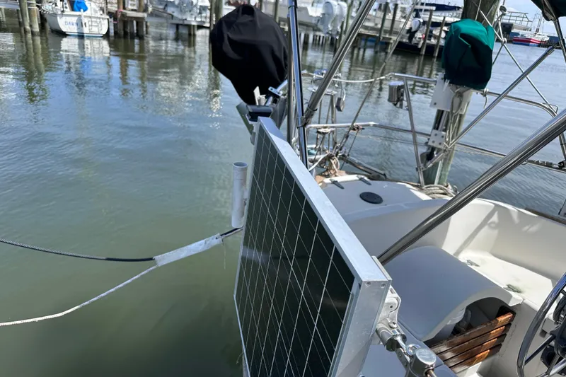 Slide: The Image of 1986 Pacific Seacraft 34 sailboat with solar panel, docked at marina. - 11