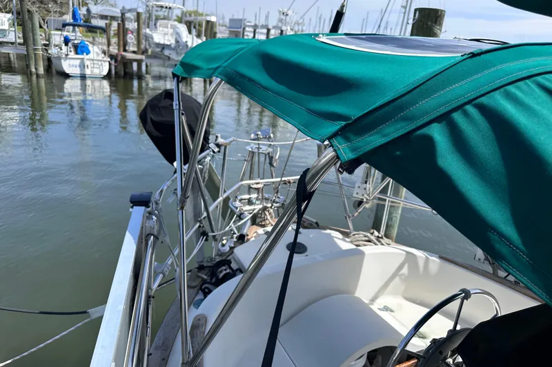 Slide: The Image of 1986 Pacific Seacraft 34 sailboat with green canopy docked at marina. - 12