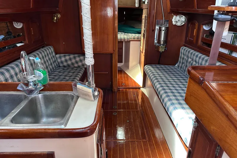 Slide: The Image of Interior of 1986 Pacific Seacraft 34 sailboat with wood finish and plaid seating. - 28