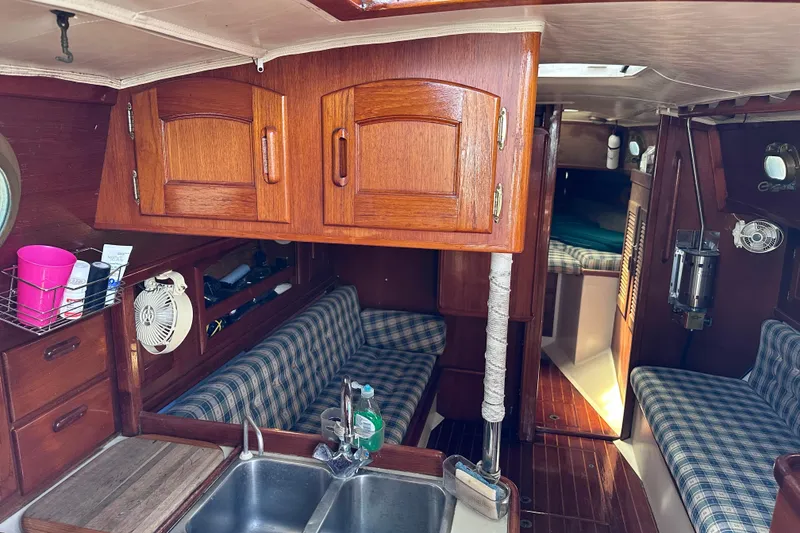 Slide: The Image of Interior of 1986 Pacific Seacraft 34 sailboat with wood cabinetry and plaid seating. - 29