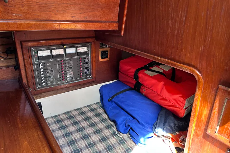 Slide: The Image of Electrical panel and storage area inside a 1986 Pacific Seacraft 34 sailboat cabin. - 36