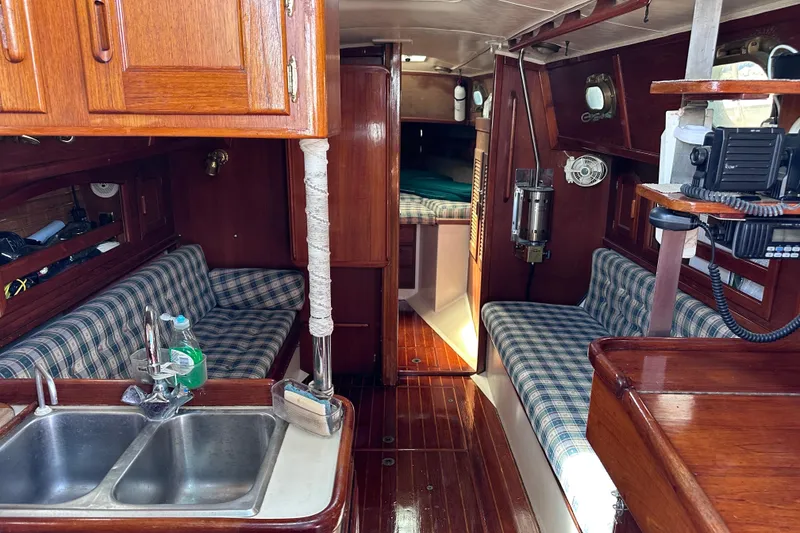 Slide: The Image of Interior of 1986 Pacific Seacraft 34 sailboat with wood finish and plaid seating. - 37