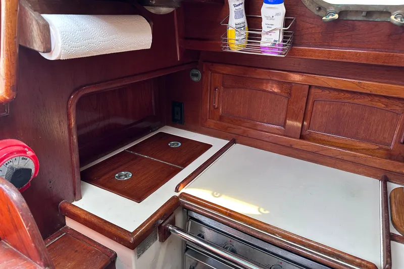 Slide: The Image of Interior of 1986 Pacific Seacraft 34 sailboat galley with wooden cabinetry and stove. - 39