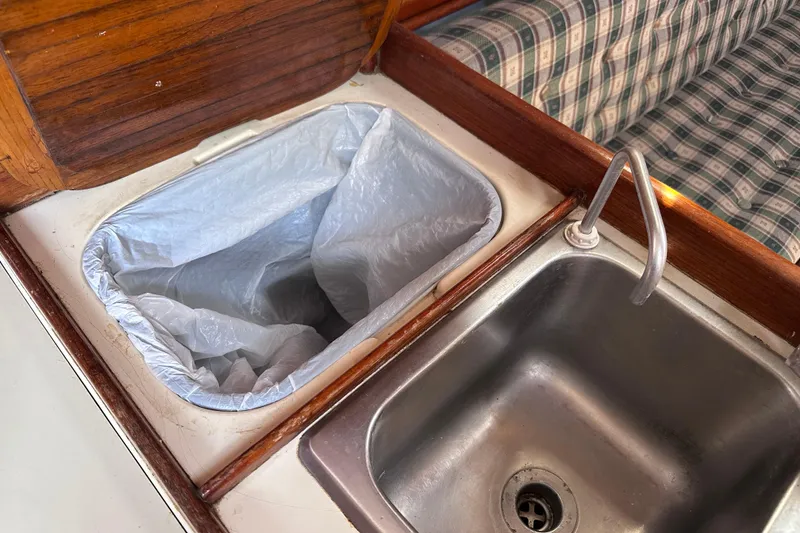 Slide: The Image of Galley sink and trash bin on 1986 Pacific Seacraft 34 sailboat interior. - 46