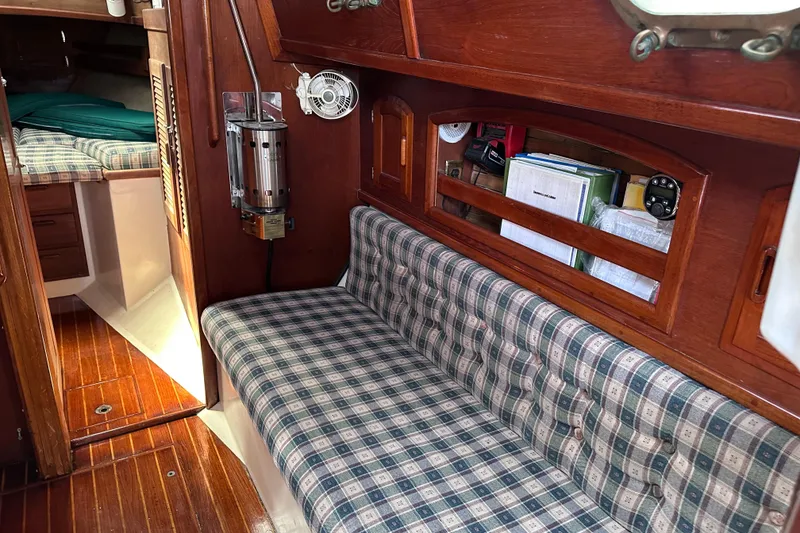 Slide: The Image of Interior of 1986 Pacific Seacraft 34 sailboat with plaid seating and wooden cabinetry. - 48