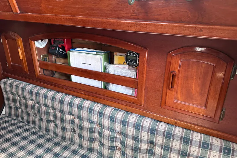 Slide: The Image of Interior of 1986 Pacific Seacraft 34 sailboat with wooden cabinets and plaid seating. - 49