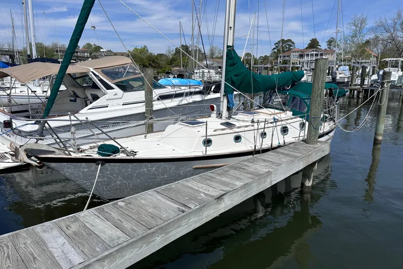 Slide: The Image of 1986 Pacific Seacraft 34 sailboat docked at a marina, surrounded by other boats. - 5