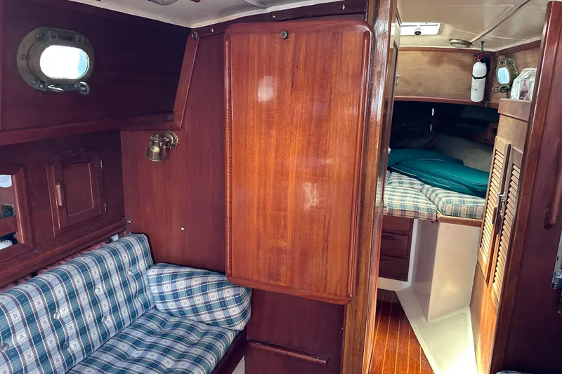 Slide: The Image of Interior of 1986 Pacific Seacraft 34 sailboat with wood paneling and plaid seating. - 51