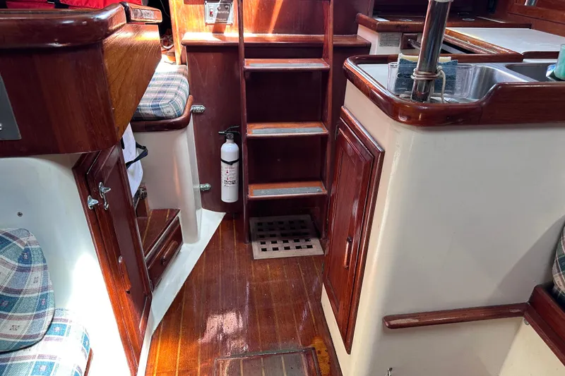 Slide: The Image of Interior of a 1986 Pacific Seacraft 34 sailboat with wooden finishes and a compact kitchen. - 53