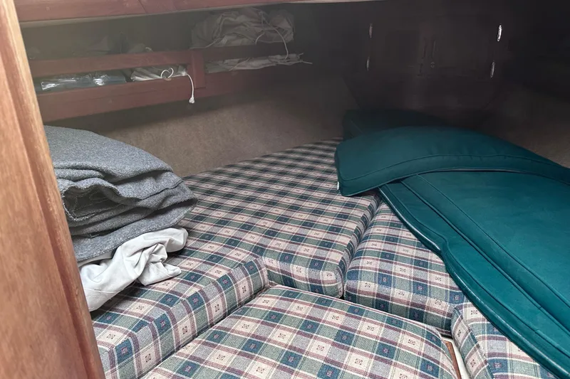 Slide: The Image of Cozy cabin interior of 1986 Pacific Seacraft 34 sailboat with plaid cushions and folded blankets. - 56