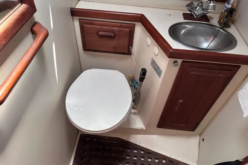 Slide: The Image of 1986 Pacific Seacraft 34 yacht bathroom with toilet, sink, and wooden cabinetry. - 58