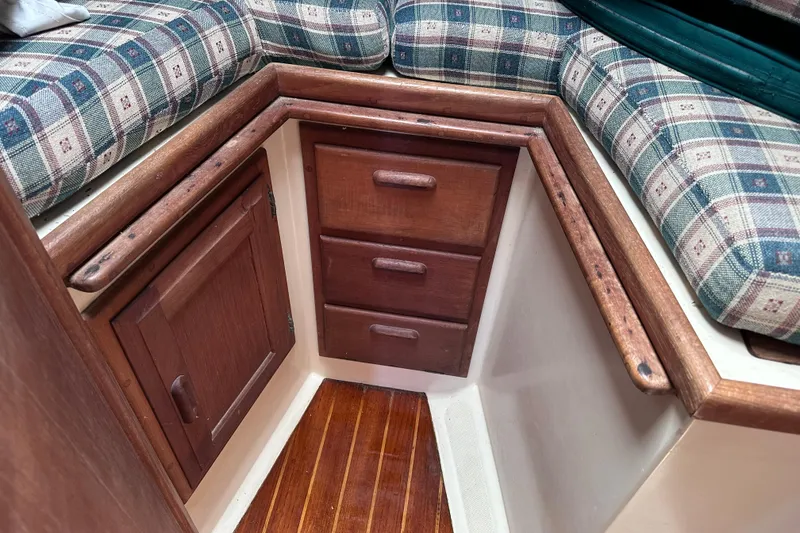 Slide: The Image of Interior of 1986 Pacific Seacraft 34 sailboat with wooden cabinetry and plaid cushions. - 59