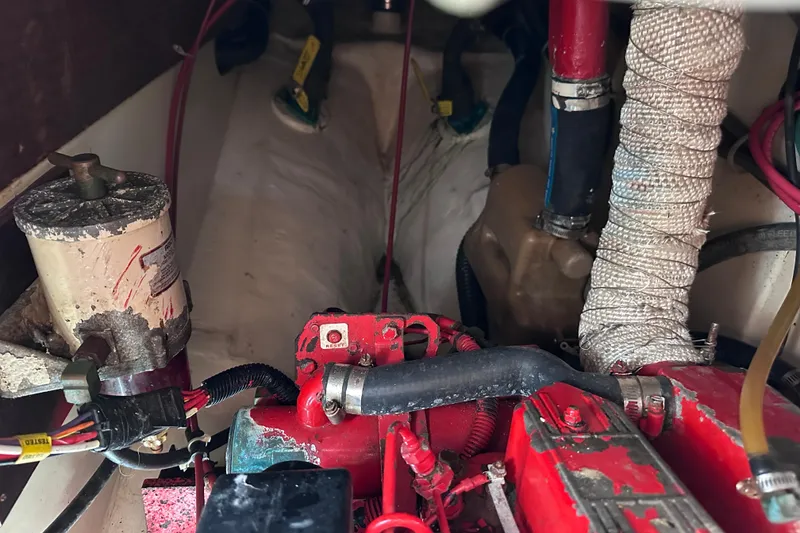 Slide: The Image of Engine compartment of a 1986 Pacific Seacraft 34 sailboat, showing hoses and components. - 63
