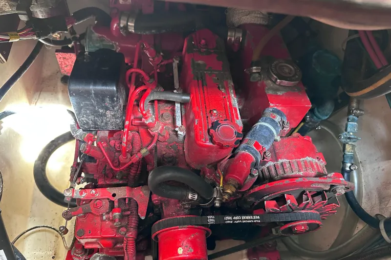 Slide: The Image of Engine compartment of a 1986 Pacific Seacraft 34 sailboat, featuring a red marine engine. - 64