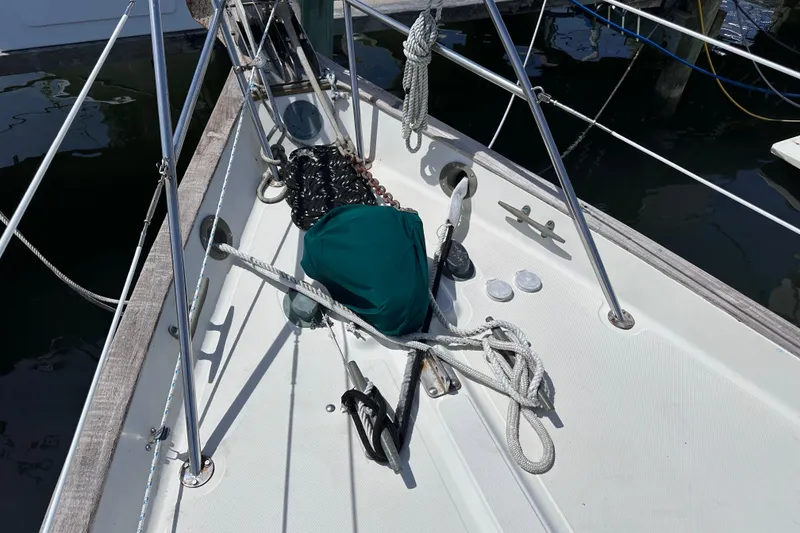 Slide: The Image of 1986 Pacific Seacraft 34 sailboat deck with ropes and anchor, docked at marina. - 8