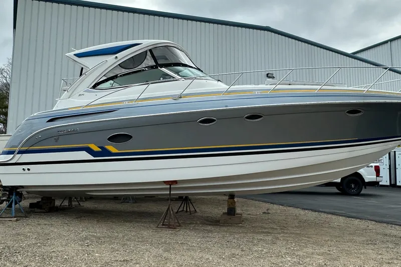 The Image of 2019 Formula 37 Performance Cruiser on stands, gray and white hull, parked outdoors. - 1