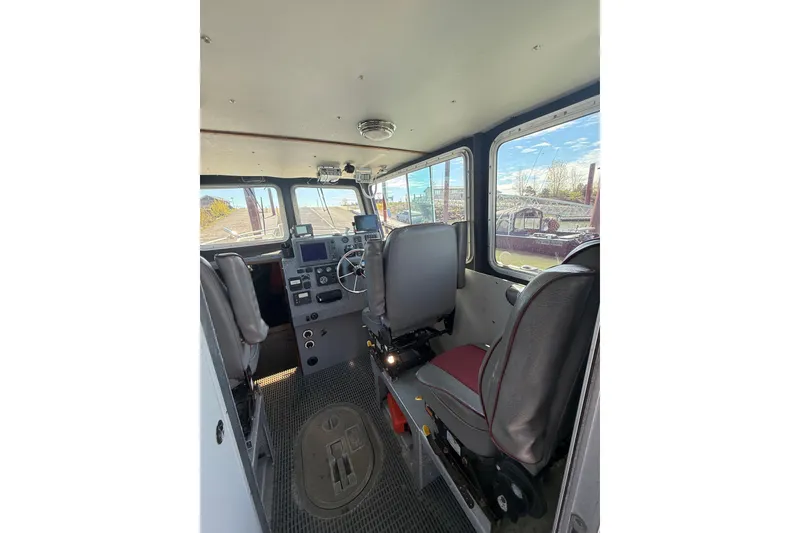 Slide: The Image of Interior of a 2004 Norsco 28 boat cockpit with steering wheel and control panels. - 10