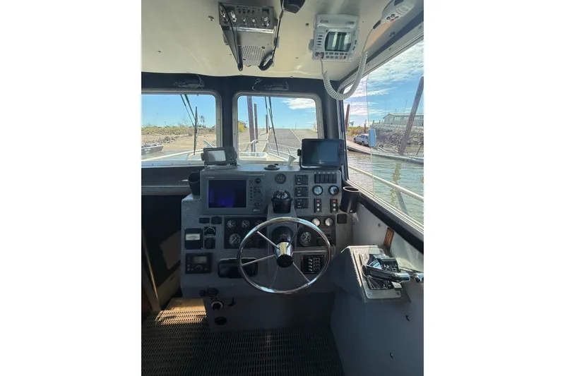 Slide: The Image of Interior view of a 2004 Norsco 28 boat cockpit with steering wheel and navigation equipment. - 12