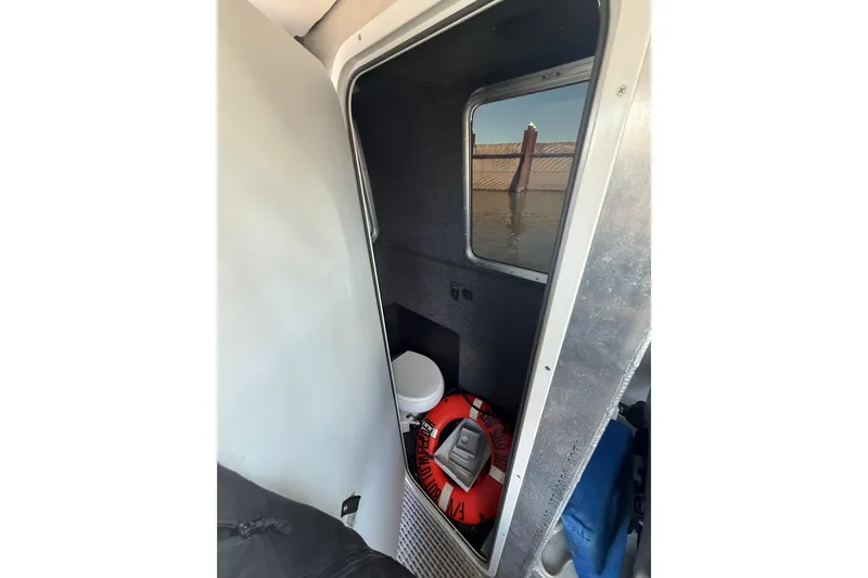 Slide: The Image of Interior of a 2004 Norsco 28 boat with a small restroom and life preserver. - 14