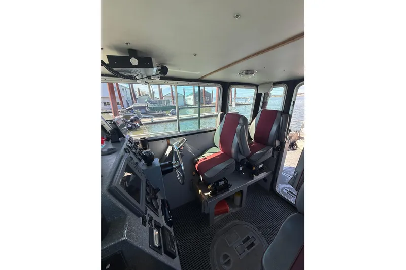 Slide: The Image of Interior of 2004 Norsco 28 boat with red seats and control panel. - 18