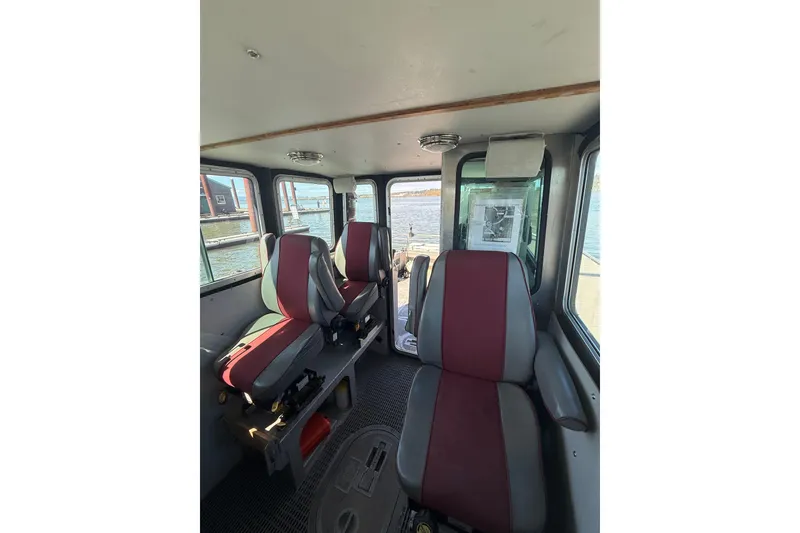 Slide: The Image of Interior of a 2004 Norsco 28 boat with red and gray seating. - 19