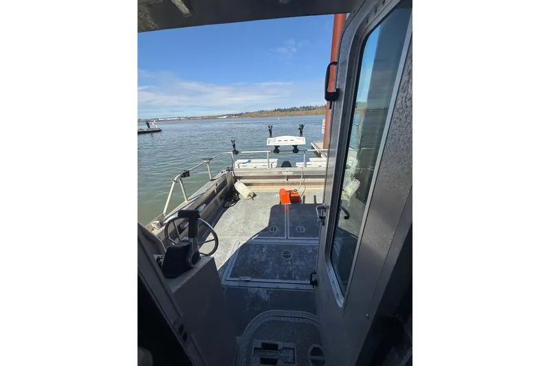 Slide: The Image of 2004 Norsco 28 boat interior view, showcasing deck and water scenery. - 20