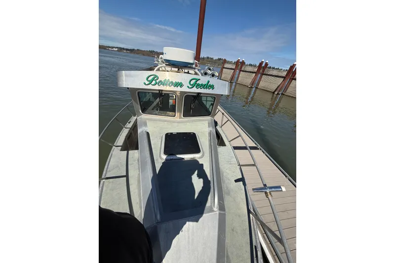 Slide: The Image of 2004 Norsco 28 boat named "Bottom Feeder" docked by the water. - 22