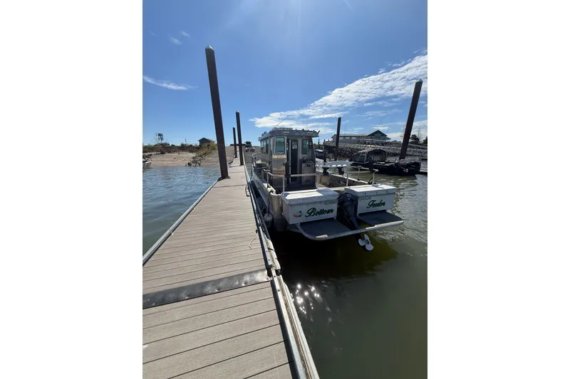 Slide: The Image of 2004 Norsco 28 boat docked at a marina under a clear blue sky. - 3