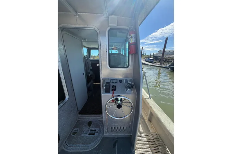 Slide: The Image of Interior view of a 2004 Norsco 28 boat, featuring steering wheel and control panel. - 8