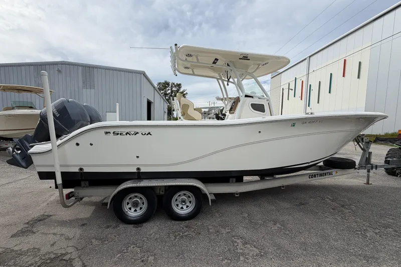 The Image of 2015 Sea Fox 266 Commander boat on trailer, parked outside a warehouse. - 0