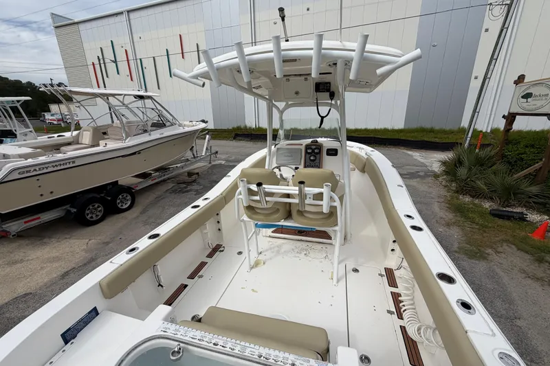 Slide: The Image of 2015 Sea Fox 266 Commander boat interior with helm and seating, docked outdoors. - 15