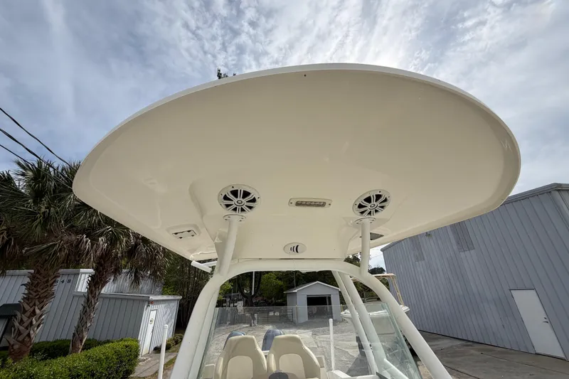 Slide: The Image of 2015 Sea Fox 266 Commander boat with T-top and speakers, parked outdoors. - 40