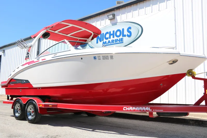 The Image of 2014 Chaparral 244 Xtreme boat with red hull on trailer at Nichols Marine. - 1