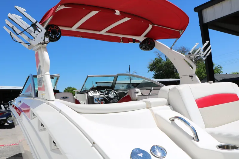Slide: The Image of 2014 Chaparral 244 Xtreme boat with red canopy and sleek interior design. - 12