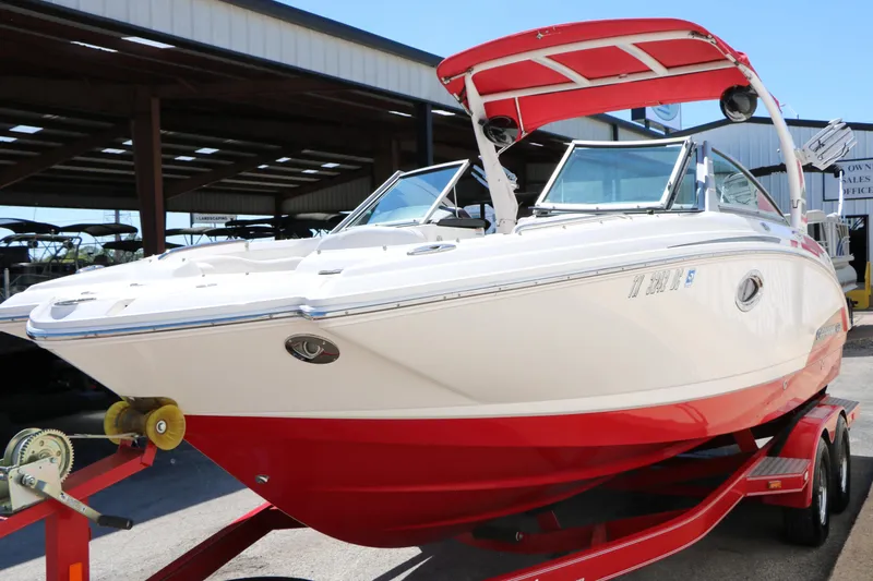 Slide: The Image of 2014 Chaparral 244 Xtreme boat with red hull on trailer in marina. - 15