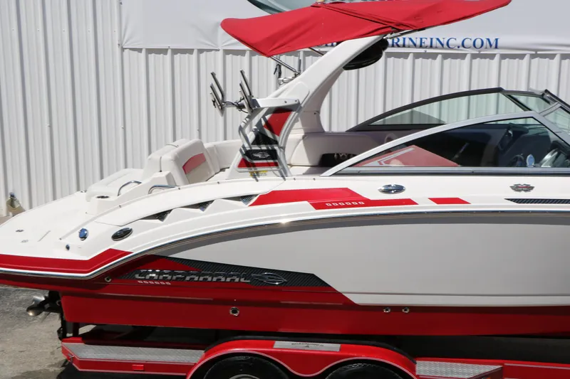 Slide: The Image of 2014 Chaparral 244 Xtreme boat with red and white design, docked outdoors. - 18