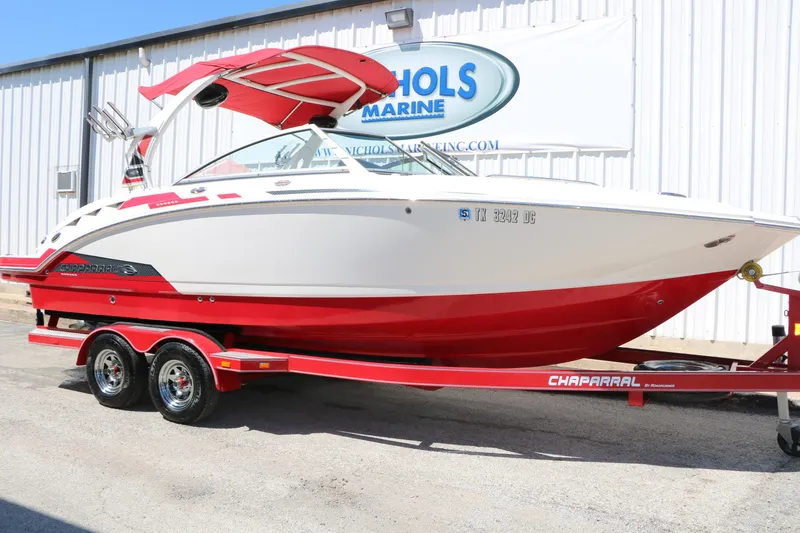 Slide: The Image of 2014 Chaparral 244 Xtreme boat on a red trailer, parked outside a marine dealership. - 2