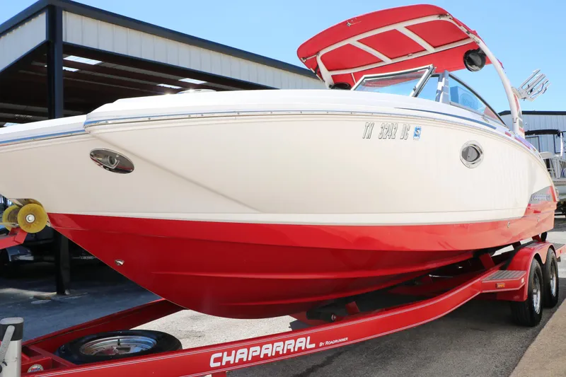 Slide: The Image of 2014 Chaparral 244 Xtreme boat with red hull on trailer, parked outdoors. - 20