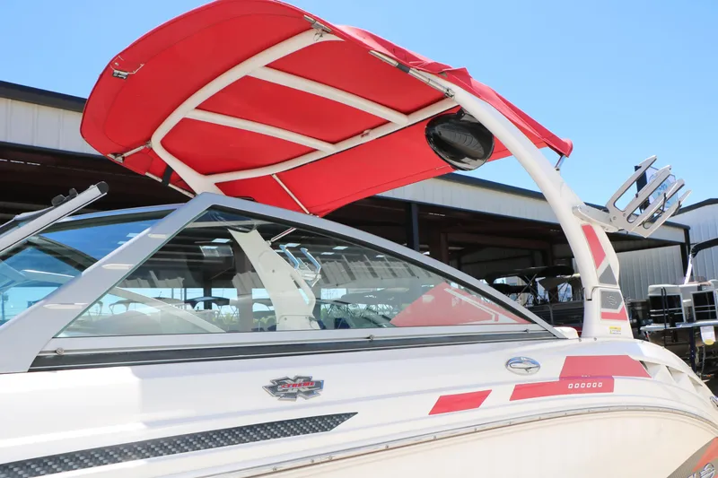 Slide: The Image of 2014 Chaparral 244 Xtreme boat with red canopy and sleek design in marina setting. - 21