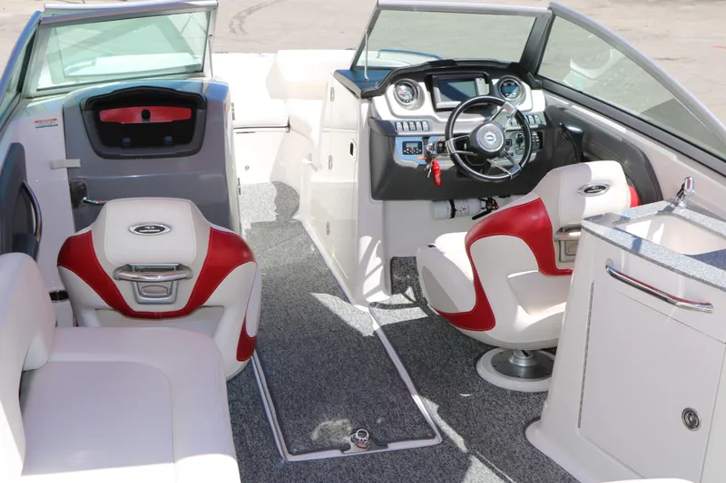 Slide: The Image of 2014 Chaparral 244 Xtreme boat interior with red and white seating, modern dashboard, and steering wheel. - 24