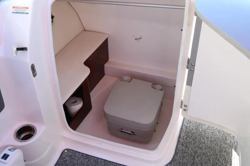 Slide: The Image of 2014 Chaparral 244 Xtreme boat interior with compact toilet and storage space. - 39