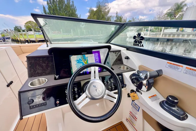 Slide: The Image of 2019 Sea Ray SDX 290 Outboard dashboard with steering wheel and navigation display. - 3