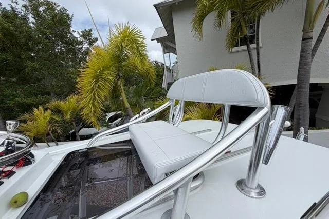 Slide: The Image of 2025 Contender 26 Bay boat with white seating, surrounded by tropical palm trees. - 13