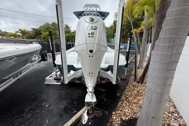 Slide: The Image of 2025 Contender 26 Bay boat with powerful outboard motor, parked outdoors. - 24