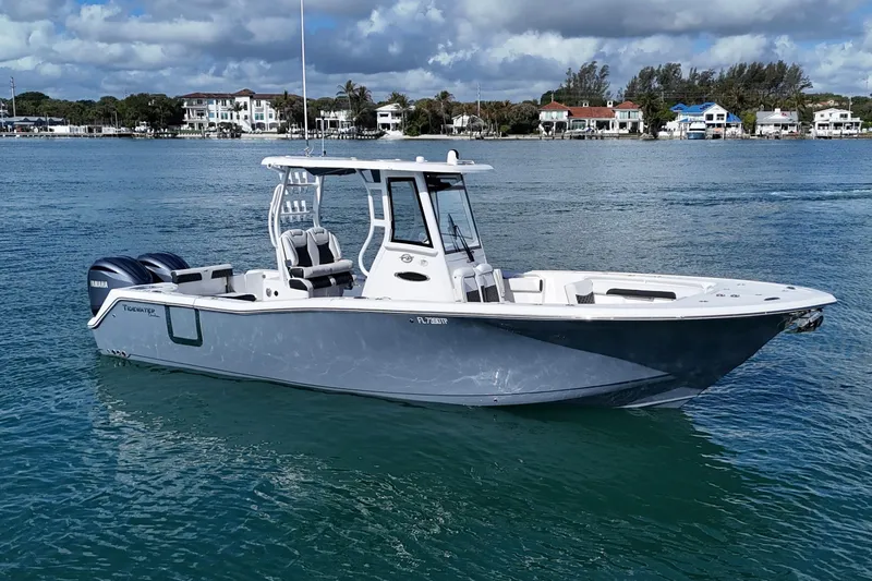 The Image of 2023 Tidewater 292 CC Adventure boat on calm water, featuring sleek design and twin engines. - 0