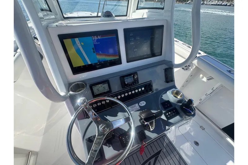 Slide: The Image of 2023 Tidewater 292 CC Adventure boat dashboard with navigation screens and controls. - 10
