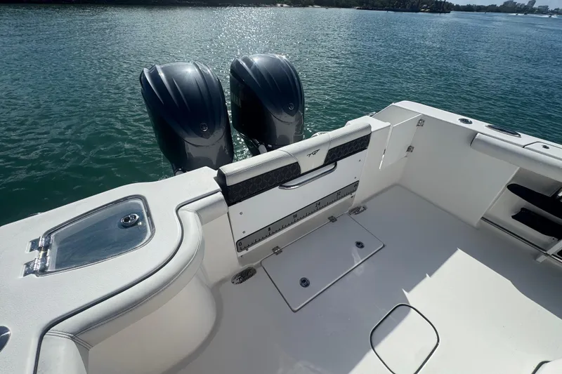 Slide: The Image of 2023 Tidewater 292 CC Adventure boat with dual outboard motors on calm water. - 14