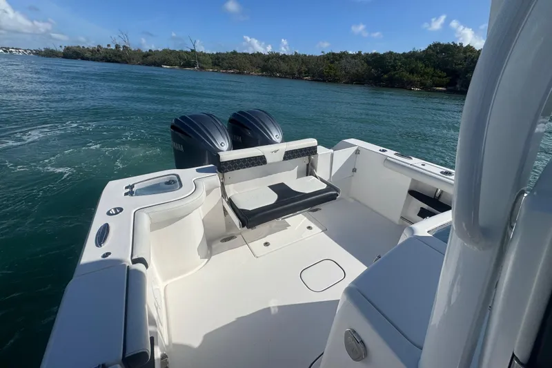 Slide: The Image of 2023 Tidewater 292 CC Adventure boat with dual engines on a scenic waterway. - 17